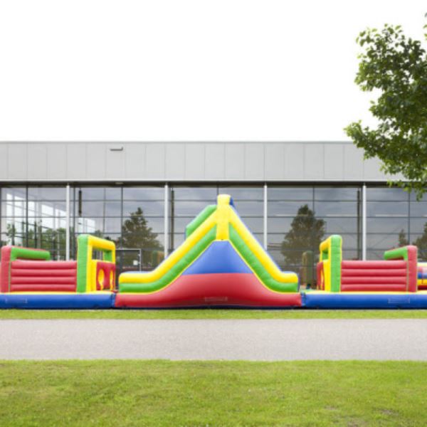 Opblaasbare stormbaan Colour Run van 21 meter met kleurrijke obstakels en glijbaan – perfect voor sportdagen en evenementen.