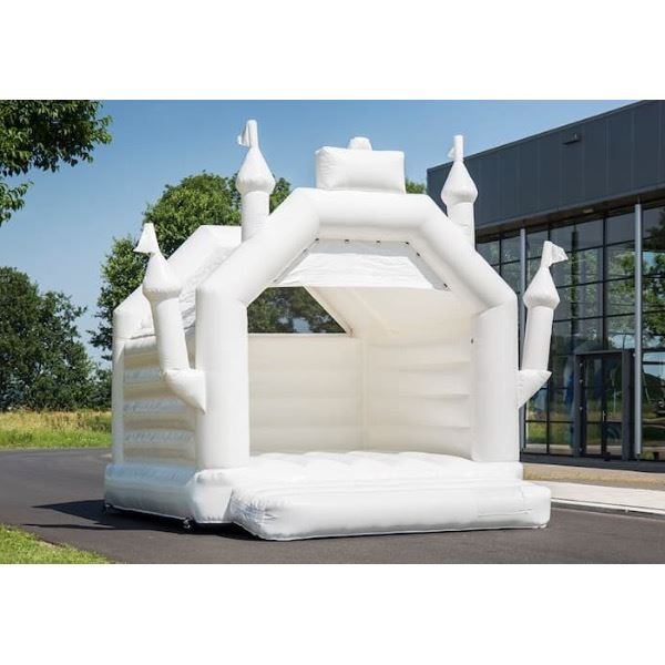 Luxe wit springkasteel tijdens een trouwfeest